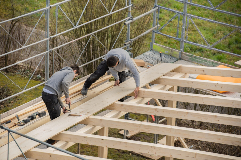 Two young carpenters building a carport.